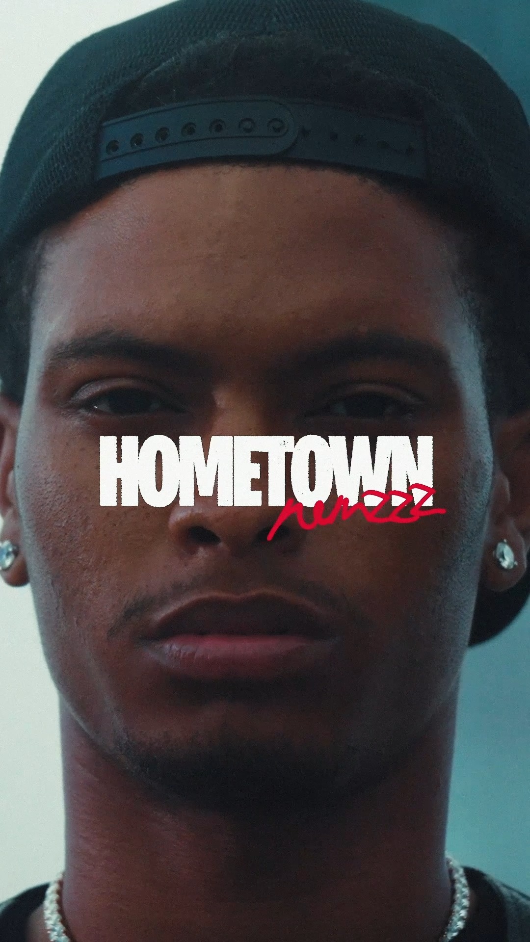 Close-up portrait of music artist Nemzzz with the bold white series title Hometown and a red handwritten signature.